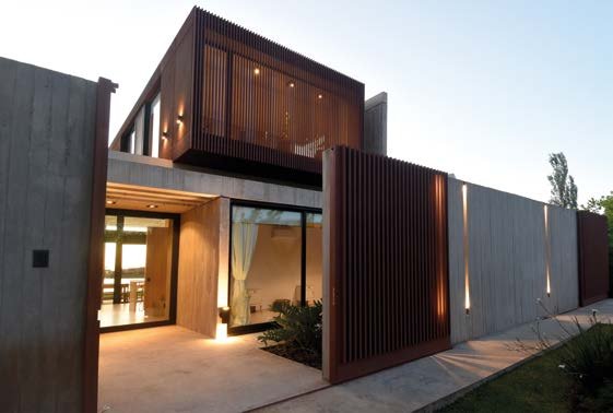 Casa Acacias: Acceso abierto y parasoles metálicos verticales al atardecer