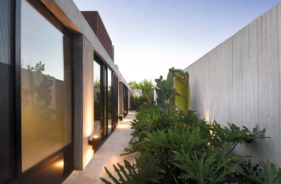 Casa Acacias: Patio verde junto a las carpinterías de piso a techo